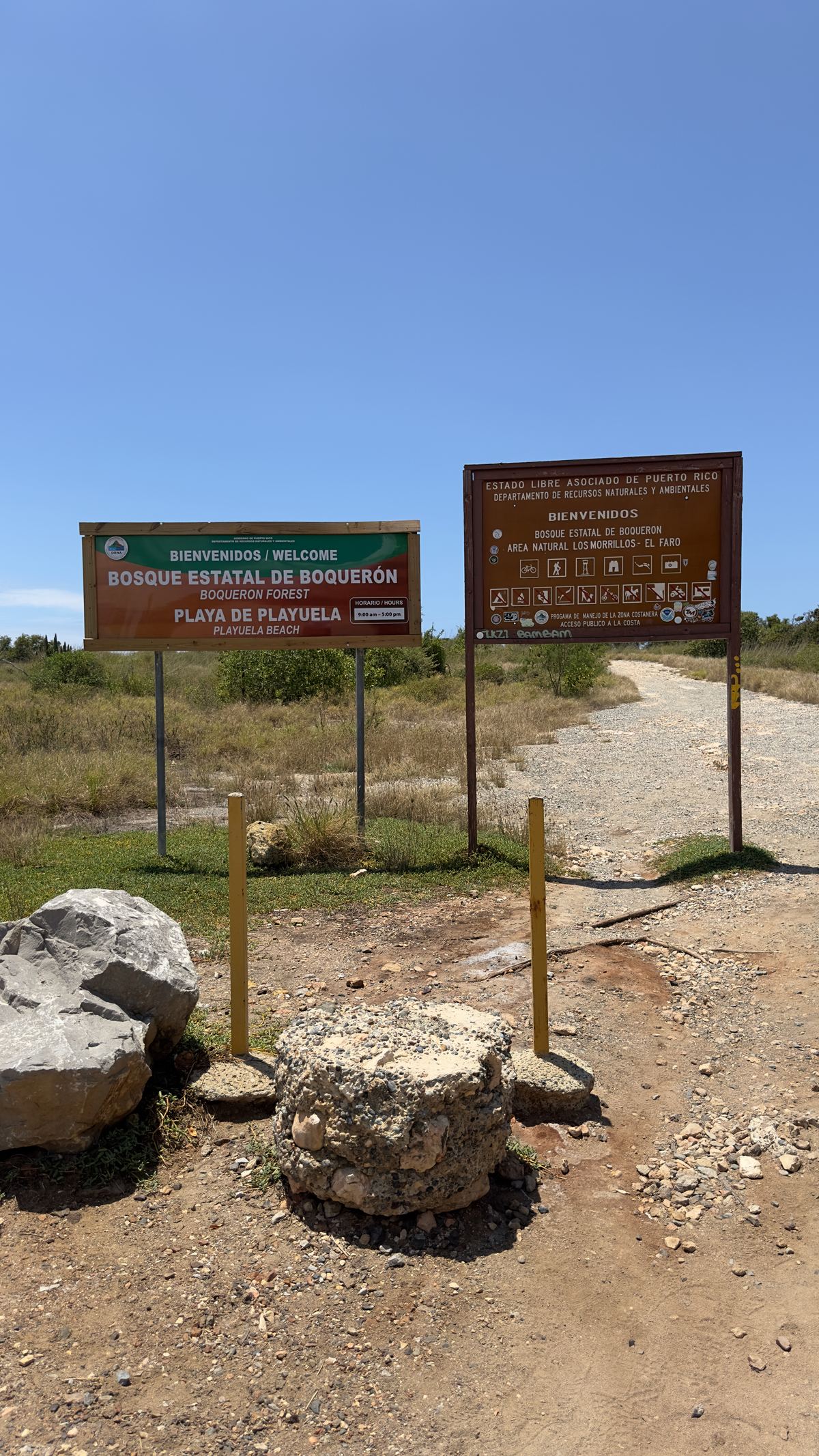 Entrada a Playuela bloqueada con postes y piedras, con los letreros oficiales de bienvenida en pie, 9 de abril de 2024